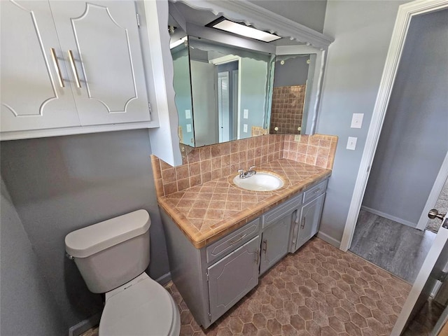 6805 Saint Marys Cir, Oklahoma City, OK 73132 - bathroom with backsplash, toilet, vanity, wood finished floors, and baseboards