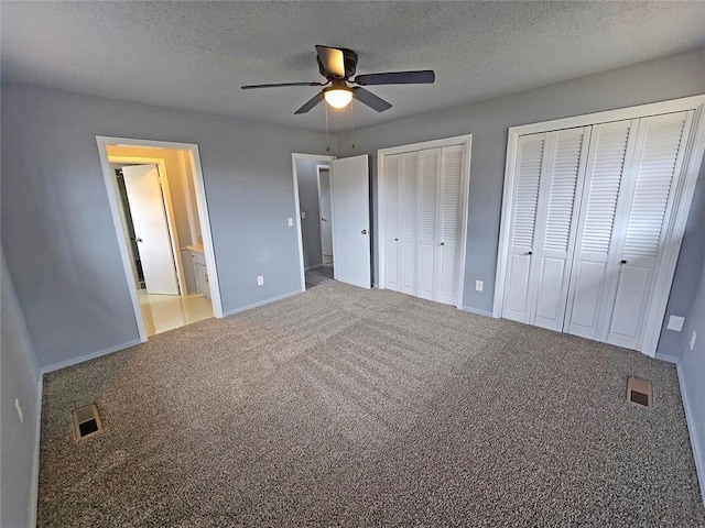 6805 Saint Marys Cir, Oklahoma City, OK 73132 - unfurnished bedroom with multiple closets, carpet floors, baseboards, a textured ceiling, and ceiling fan