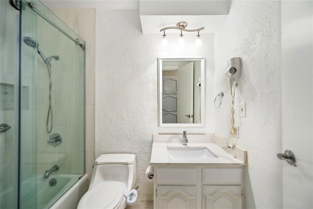 410 NW Taylor Ave, Piedmont, OK 73078 - bathroom with a textured wall, toilet, vanity, and enclosed tub / shower combo