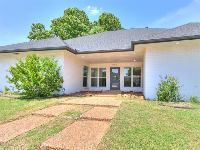 6001 Broadmoor Ave, Oklahoma City, OK 73132 - property entrance featuring brick siding, a lawn, and roof with shingles