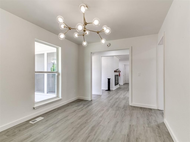 6001 Broadmoor Ave, Oklahoma City, OK 73132 - unfurnished room featuring light wood-style flooring, a chandelier, and baseboards
