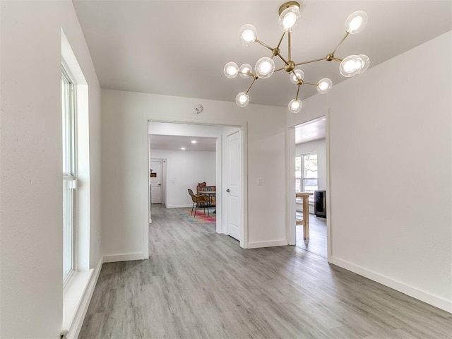 6001 Broadmoor Ave, Oklahoma City, OK 73132 - empty room featuring light wood-style flooring, a chandelier, baseboards, and a smoke detector