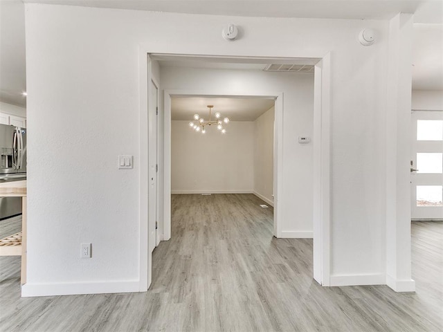 6001 Broadmoor Ave, Oklahoma City, OK 73132 - spare room with baseboards, light wood-style floors, a chandelier, and a smoke detector
