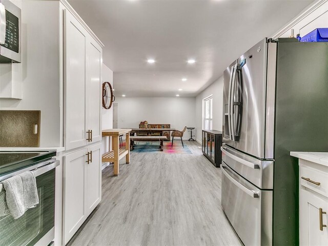 6001 Broadmoor Ave, Oklahoma City, OK 73132 - kitchen with stainless steel appliances, white cabinetry, light wood-style flooring, light countertops, and recessed lighting