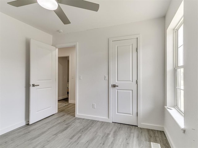 6001 Broadmoor Ave, Oklahoma City, OK 73132 - unfurnished bedroom with light wood finished floors, multiple windows, and baseboards