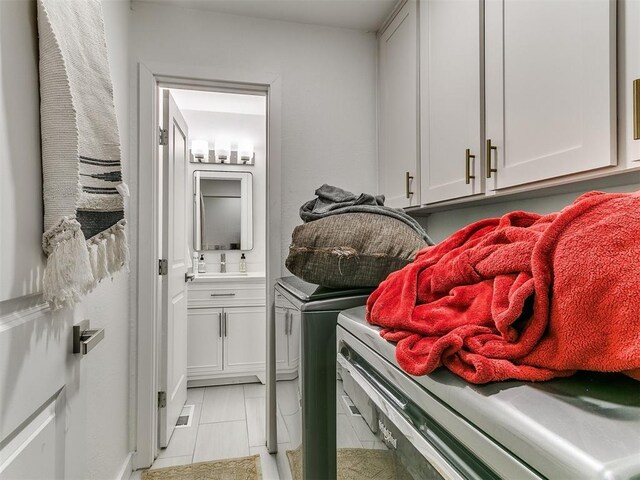 6001 Broadmoor Ave, Oklahoma City, OK 73132 - washroom featuring independent washer and dryer and cabinet space