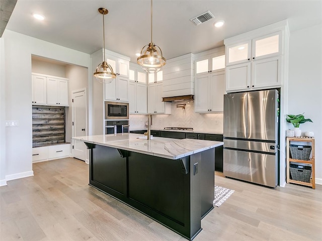 222 Alamosa Rd, Norman, OK 73069 - kitchen with appliances with stainless steel finishes, light wood finished floors, backsplash, white cabinetry, and recessed lighting
