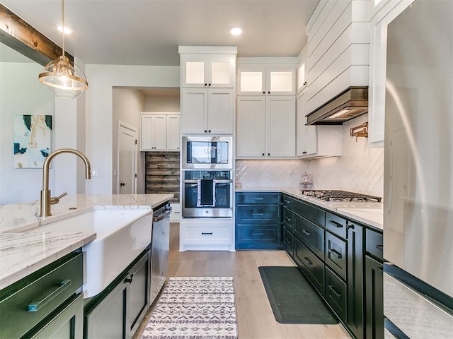 222 Alamosa Rd, Norman, OK 73069 - kitchen with appliances with stainless steel finishes, white cabinets, custom range hood, a sink, and decorative backsplash