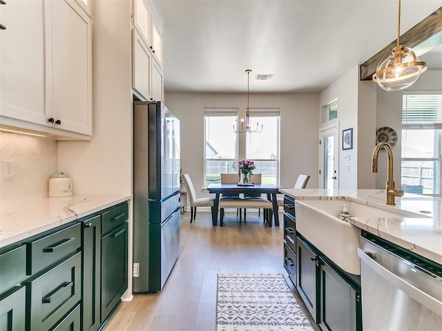 222 Alamosa Rd, Norman, OK 73069 - kitchen with appliances with stainless steel finishes, green cabinetry, light wood finished floors, and white cabinetry