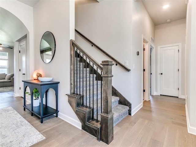 222 Alamosa Rd, Norman, OK 73069 - stairway featuring wood finished floors, baseboards, arched walkways, and a ceiling fan