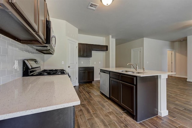 9749 Livingston Rd, Edmond, OK 73025 - kitchen with stainless steel appliances, dark wood-type flooring, dark brown cabinets, a sink, and baseboards