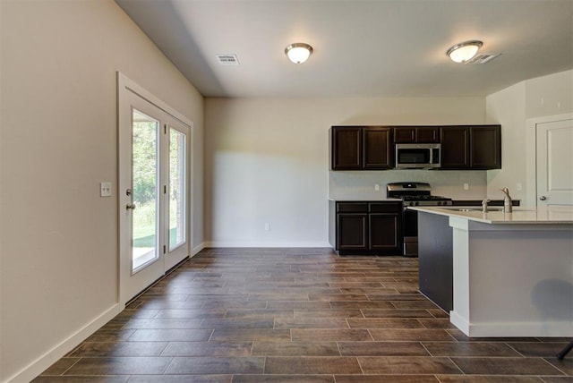 9749 Livingston Rd, Edmond, OK 73025 - kitchen featuring stainless steel appliances, dark wood finished floors, light countertops, and baseboards