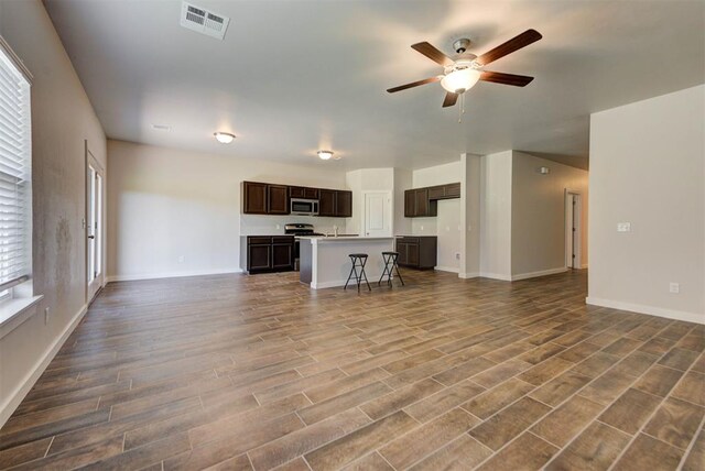 9749 Livingston Rd, Edmond, OK 73025 - unfurnished living room featuring a ceiling fan, dark wood-style floors, and baseboards