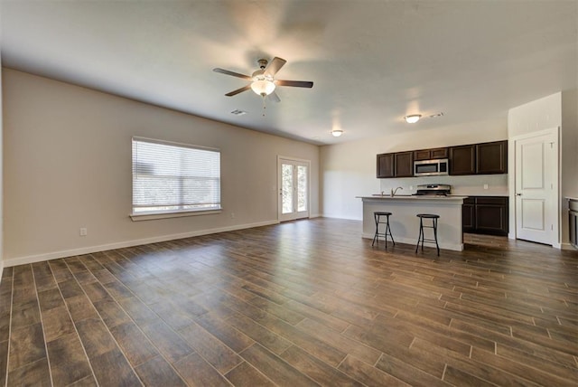 9749 Livingston Rd, Edmond, OK 73025 - unfurnished living room featuring ceiling fan, dark wood finished floors, and baseboards