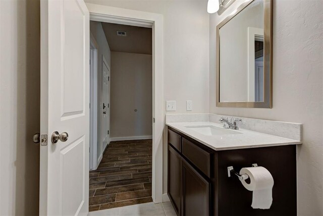 9749 Livingston Rd, Edmond, OK 73025 - bathroom featuring vanity, wood tiled floors, and baseboards