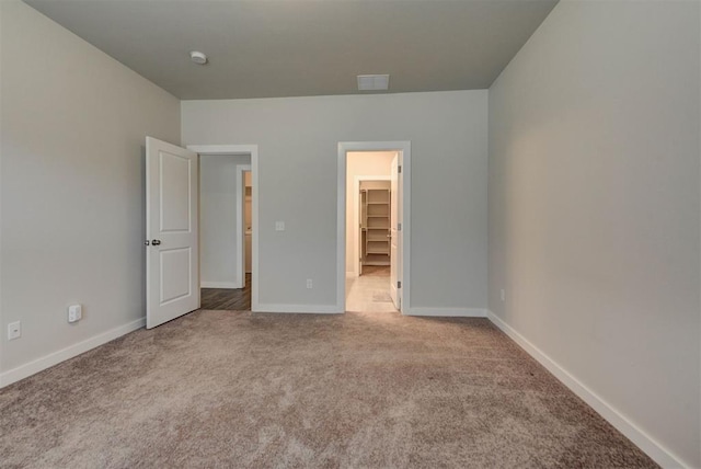 9749 Livingston Rd, Edmond, OK 73025 - unfurnished bedroom with a walk in closet, carpet flooring, baseboards, and a closet