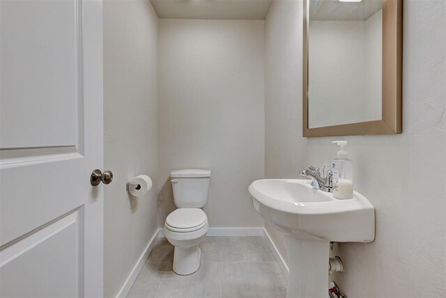 9749 Livingston Rd, Edmond, OK 73025 - half bathroom featuring toilet, tile patterned flooring, and baseboards