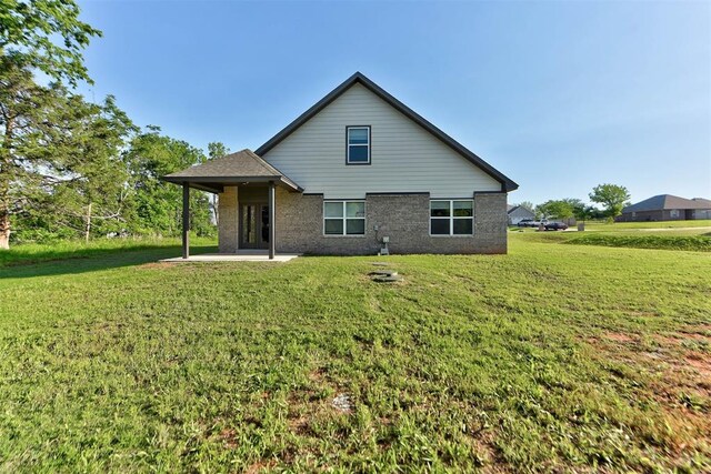 9749 Livingston Rd, Edmond, OK 73025 - back of property featuring a patio, a lawn, and brick siding