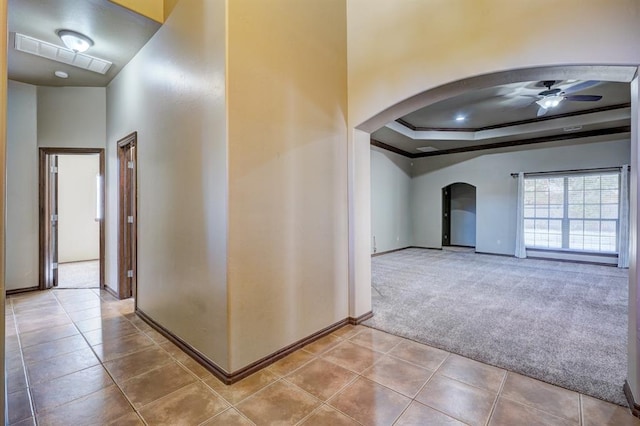 924 Regal Rd, Yukon, OK 73099 - corridor featuring arched walkways, baseboards, carpet flooring, and a tray ceiling