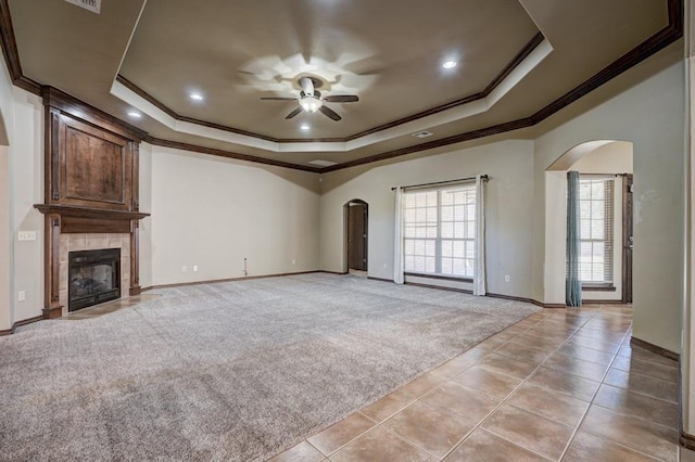 924 Regal Rd, Yukon, OK 73099 - unfurnished living room with arched walkways, a raised ceiling, light colored carpet, ornamental molding, and ceiling fan