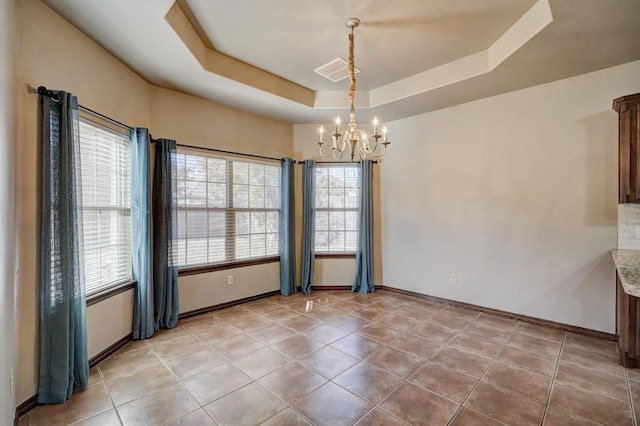 924 Regal Rd, Yukon, OK 73099 - unfurnished room featuring a chandelier, a tray ceiling, baseboards, and light tile patterned flooring
