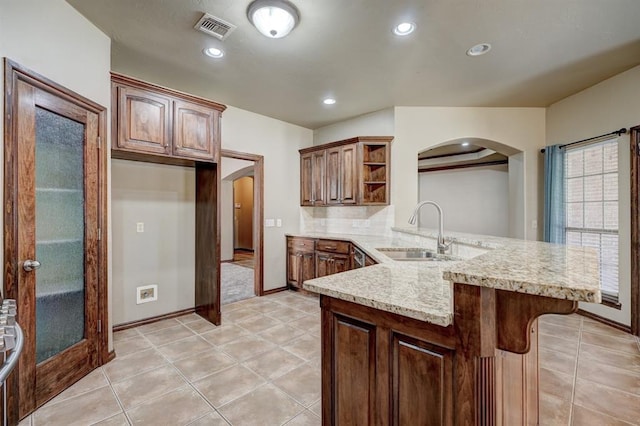924 Regal Rd, Yukon, OK 73099 - kitchen featuring arched walkways, a sink, open shelves, a peninsula, and recessed lighting