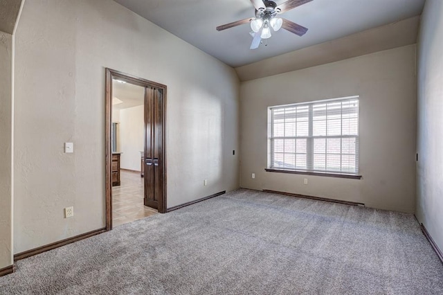 924 Regal Rd, Yukon, OK 73099 - empty room featuring a ceiling fan, light carpet, vaulted ceiling, and baseboards