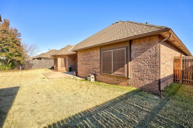 924 Regal Rd, Yukon, OK 73099 - rear view of house featuring brick siding, a shingled roof, and a patio area