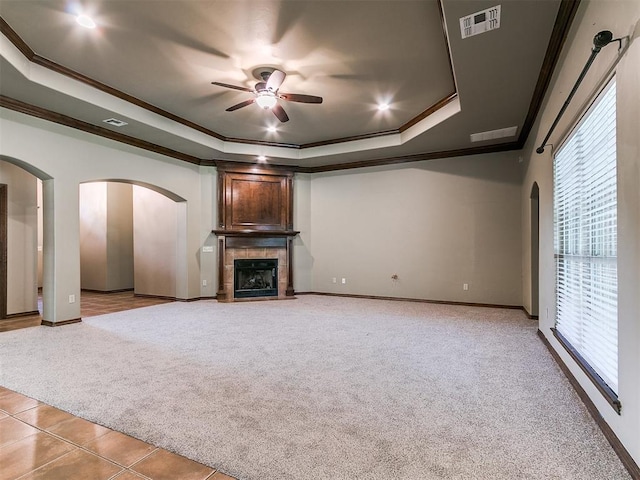 924 Regal Rd, Yukon, OK 73099 - unfurnished living room with a raised ceiling, ornamental molding, light colored carpet, a ceiling fan, and plenty of natural light