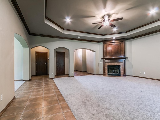 924 Regal Rd, Yukon, OK 73099 - unfurnished living room with crown molding, ceiling fan, a tray ceiling, baseboards, and arched walkways