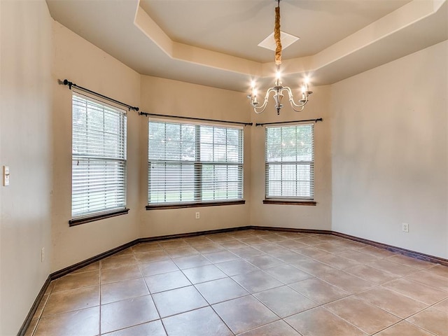 924 Regal Rd, Yukon, OK 73099 - empty room featuring light tile patterned floors, a chandelier, healthy amount of natural light, and a raised ceiling