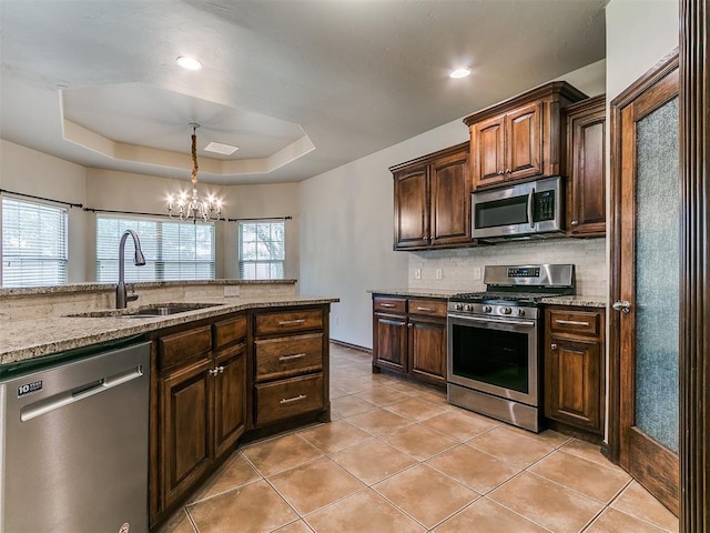 924 Regal Rd, Yukon, OK 73099 - kitchen with appliances with stainless steel finishes, a sink, light tile patterned floors, a chandelier, and light stone countertops