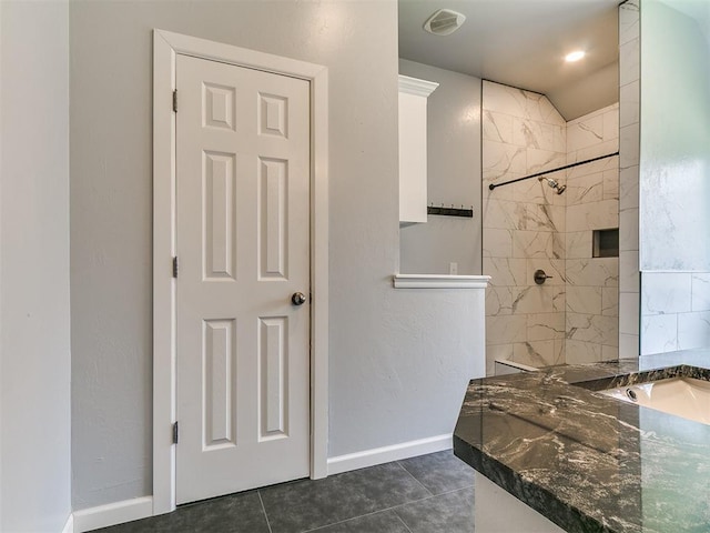 924 Regal Rd, Yukon, OK 73099 - bathroom featuring a tile shower, baseboards, and tile patterned floors