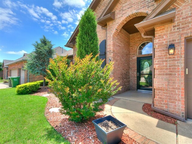 924 Regal Rd, Yukon, OK 73099 - view of exterior entry featuring brick siding and a yard