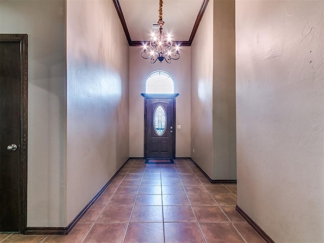 924 Regal Rd, Yukon, OK 73099 - entryway with ornamental molding, a chandelier, dark tile patterned flooring, and baseboards