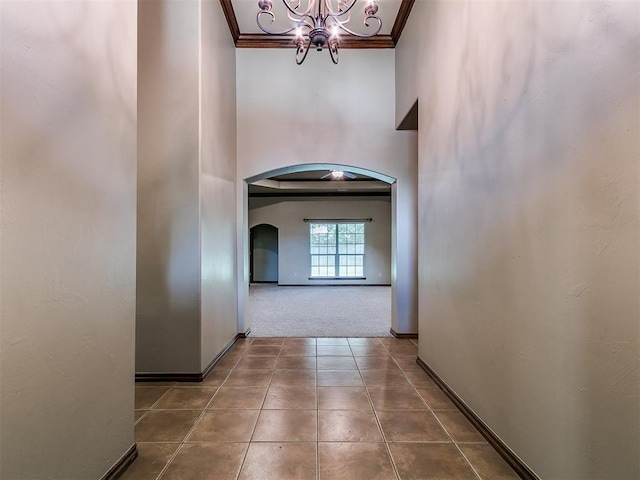 924 Regal Rd, Yukon, OK 73099 - hallway featuring arched walkways, a chandelier, ornamental molding, carpet floors, and baseboards