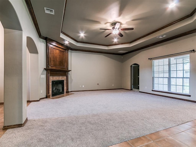 924 Regal Rd, Yukon, OK 73099 - unfurnished living room featuring light carpet, arched walkways, a ceiling fan, a raised ceiling, and ornamental molding