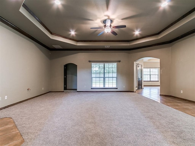924 Regal Rd, Yukon, OK 73099 - carpeted empty room with arched walkways, a tray ceiling, ornamental molding, a ceiling fan, and recessed lighting