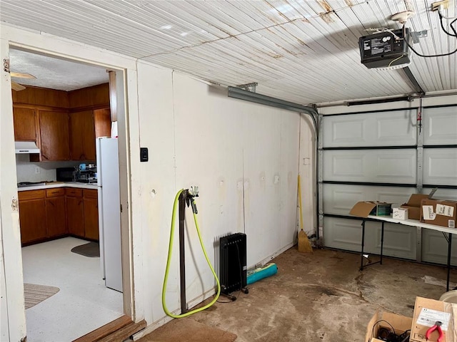 321 E Ninth St, Leedey, OK 73654 - garage with a garage door opener and freestanding refrigerator