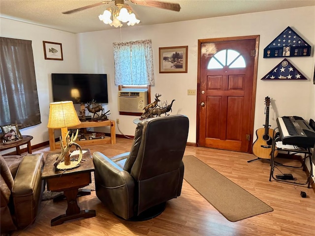 321 E Ninth St, Leedey, OK 73654 - living area with a ceiling fan, wood finished floors, baseboards, cooling unit, and a textured ceiling