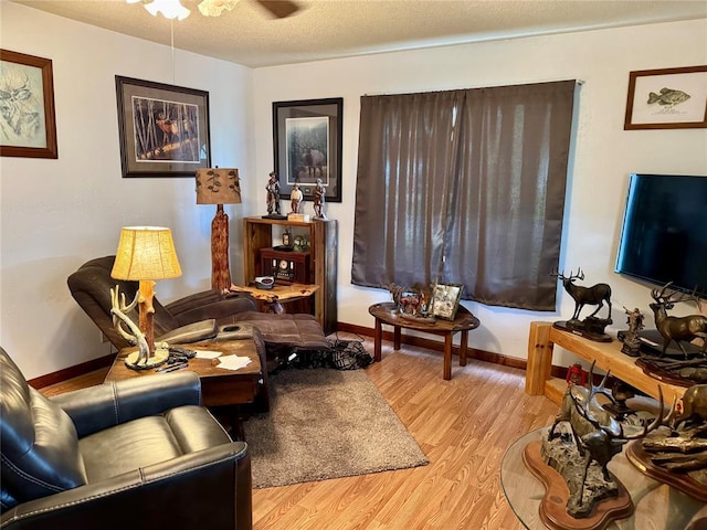 321 E Ninth St, Leedey, OK 73654 - living area featuring light wood-style floors, a ceiling fan, baseboards, and a textured ceiling