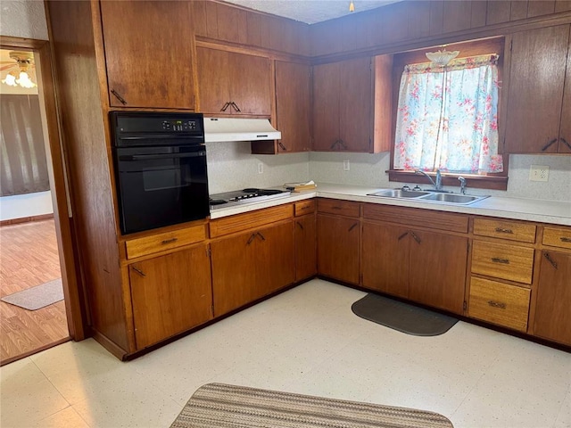 321 E Ninth St, Leedey, OK 73654 - kitchen featuring black oven, a sink, stainless steel stovetop, under cabinet range hood, and light floors