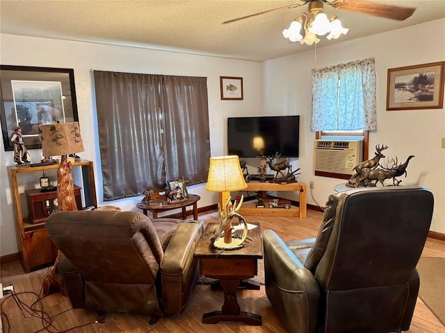 321 E Ninth St, Leedey, OK 73654 - living room with wood finished floors, a ceiling fan, cooling unit, baseboards, and a textured ceiling