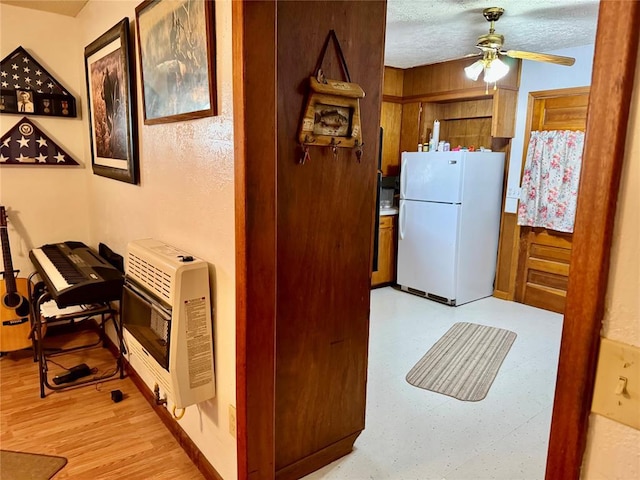 321 E Ninth St, Leedey, OK 73654 - kitchen featuring freestanding refrigerator, heating unit, a ceiling fan, light floors, and brown cabinetry