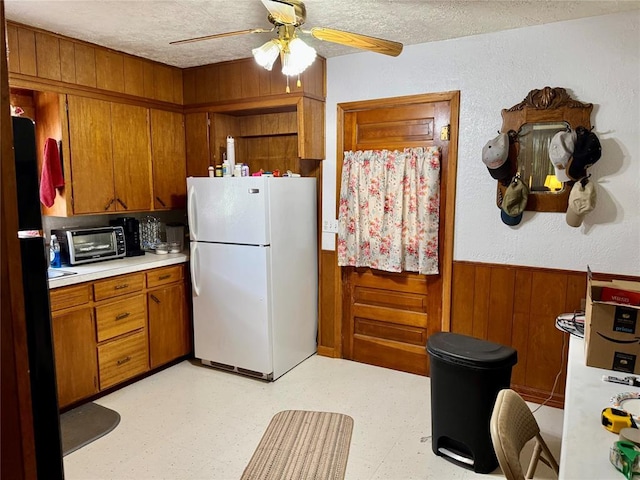 321 E Ninth St, Leedey, OK 73654 - kitchen featuring freestanding refrigerator, a wainscoted wall, light countertops, wood walls, and light flooring