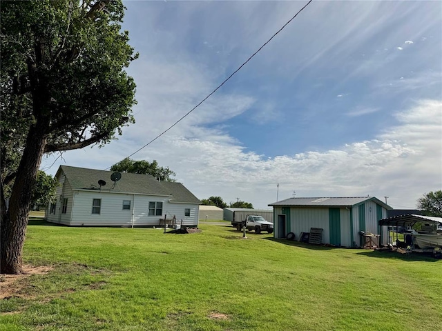 321 E Ninth St, Leedey, OK 73654 - view of grassy yard with an outbuilding and a carport