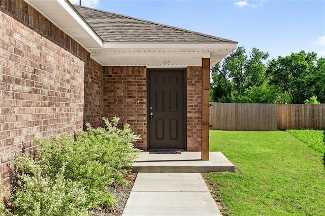 doorway to property with brick siding and roof with shingles