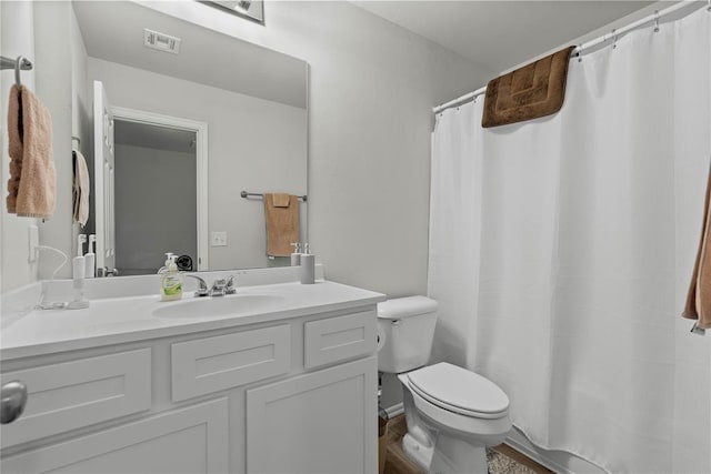full bath featuring toilet, vanity, and curtained shower