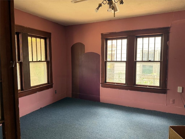 711 E Walnut St, Altus, OK 73521 - carpeted empty room featuring arched walkways and a ceiling fan