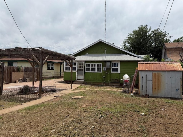 711 E Walnut St, Altus, OK 73521 - back of house with a patio, a pergola, entry steps, a storage unit, and fence